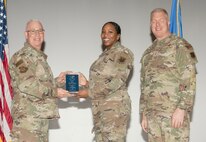 U.S. Air Force Col. Harley P. Thompson, left, commander of the 99th Mission Support Group (MSG), and Chief Master Sgt. Scott Castrovinci, right, Senior Enlisted Leader of the 99th MSG, present the Noncommissioned Officer of the Quarter award to Staff Sgt. Tiffany Jones, a contract specialist assigned to the 99th Contracting Squadron, during the third quarter awards at Nellis Air Force Base, Nevada, Oct. 29, 2024.