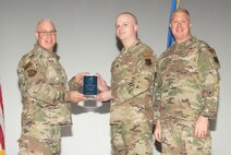 U.S. Air Force Col. Harley P. Thompson, left, commander of the 99th Mission Support Group (MSG), and Chief Master Sgt. Scott Castrovinci, Senior Enlisted Leader of the 99th MSG, right, present the Company Grade Officer of the Quarter award to Capt. Curtis Rosebery, a vehicle management flight commander assigned to the 99th Logistics Readiness Squadron, during the third quarter awards at Nellis Air Force Base, Nevada, Oct. 29, 2024.