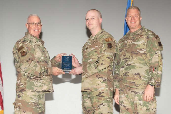 U.S. Air Force Col. Harley P. Thompson, left, commander of the 99th Mission Support Group (MSG), and Chief Master Sgt. Scott Castrovinci, Senior Enlisted Leader of the 99th MSG, right, present the Company Grade Officer of the Quarter award to Capt. Curtis Rosebery, a vehicle management flight commander assigned to the 99th Logistics Readiness Squadron, during the third quarter awards at Nellis Air Force Base, Nevada, Oct. 29, 2024.