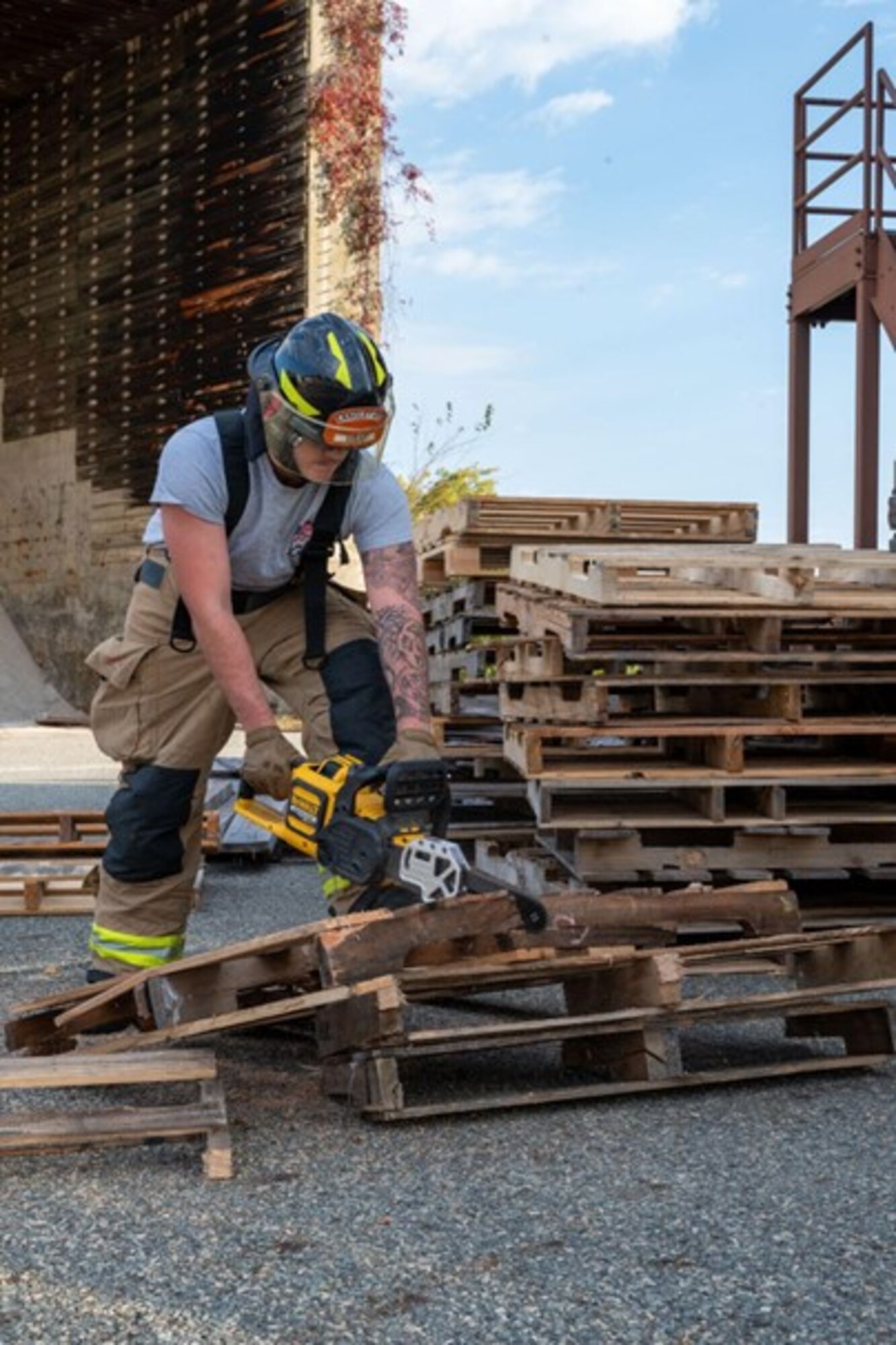 Firefighter cuts pallets with a chainsaw. (U.S. Air Force photo by Airman Donnell Ramsey)