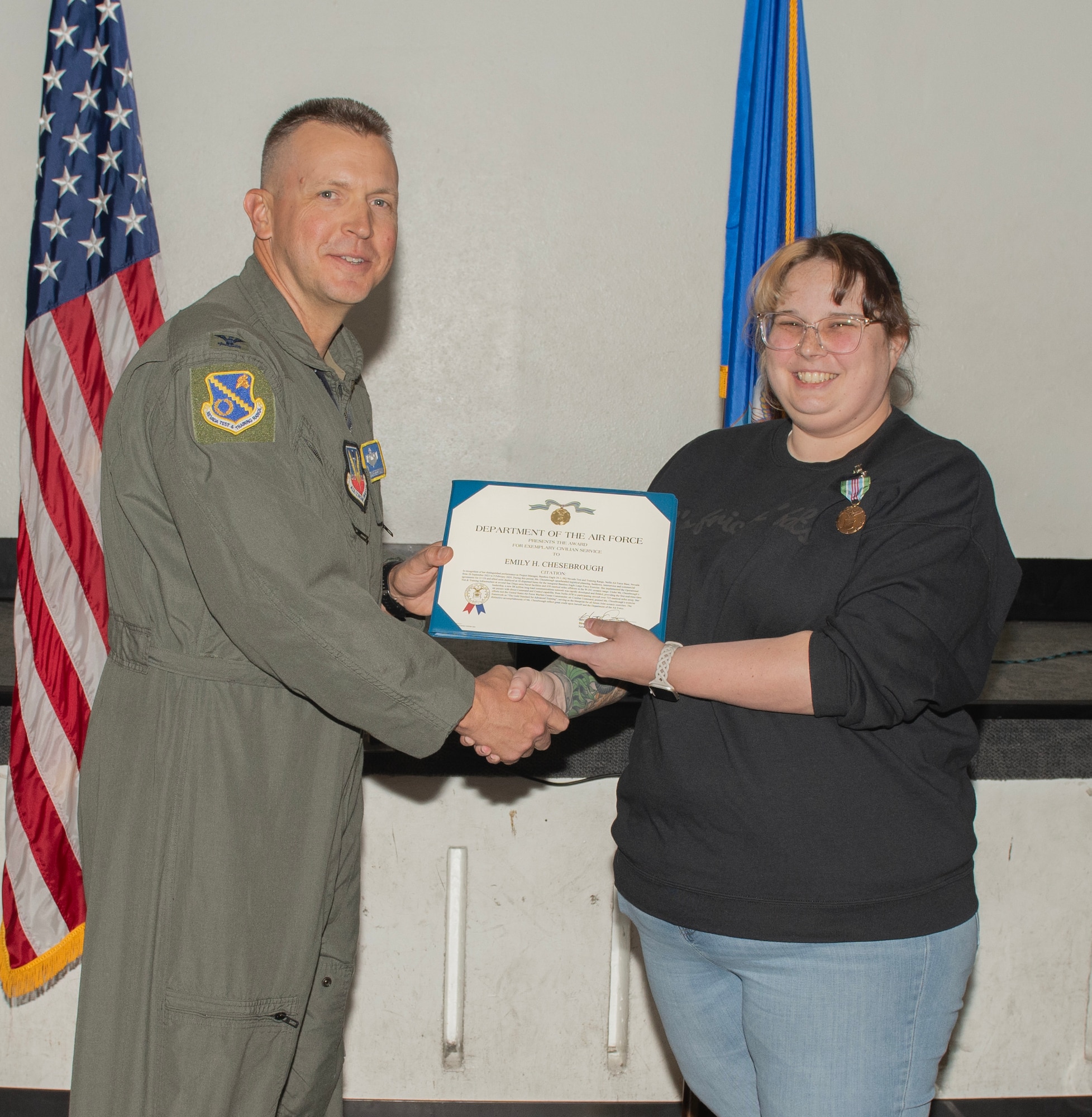 U.S. Air Force Col. Dane J. Gehrmann, commander of the Nevada Test and Training Range (NTTR), presents the Air Force Exemplary Civilian Service award to Emily Chesebrough, a range operations specialist assigned to NTTR, during a commander’s call at Nellis Air Force Base, Nevada, Oct. 31, 2024.