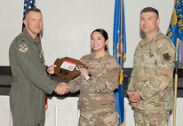 U.S. Air Force Col. Dane J. Gehrmann, left, commander of the Nevada Test and Training Range (NTTR), and Senior Master Sgt. Dennis Kolesnik, right, senior enlisted leader assigned to NTTR, present the Noncommissioned Officer of the Quarter award to Staff Sgt. Heather Callahan, NCO in charge of client systems operations assigned to NTTR, during a commander’s call at Nellis Air Force Base, Nevada, Oct. 31, 2024.