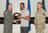 U.S. Air Force Col. Dane J. Gehrmann, left, commander of the Nevada Test and Training Range (NTTR), and Senior Master Sgt. Dennis Kolesnik, right, senior enlisted leader assigned to NTTR, present the Civilian Category I of the Quarter award to Kevin Seals, a unit program coordinator assigned to NTTR during a commander’s call at Nellis Air Force Base, Nevada, Oct. 31, 2024.