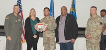 U.S. Air Force Col. Dane J. Gehrmann, left, commander of the Nevada Test and Training Range (NTTR), and Senior Master Sgt. Dennis Kolesnik, right, senior enlisted leader assigned to NTTR, present the Team of the Quarter award to the financial management team assigned to NTTR during a commander’s call at Nellis Air Force Base, Nevada, Oct. 31, 2024.
