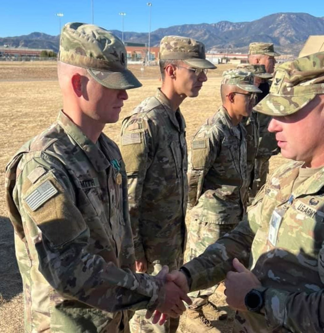 Col. Andy Kiser, right, commander of 2nd Stryker Brigade Combat Team, 4th Infantry Division, Fort Carson, Colorado, congratulates Capt. Kyle Smith, a logistics officer with 4th ID, for receiving an Army Commendation after a National Training Center rotation. (Courtesy photo)