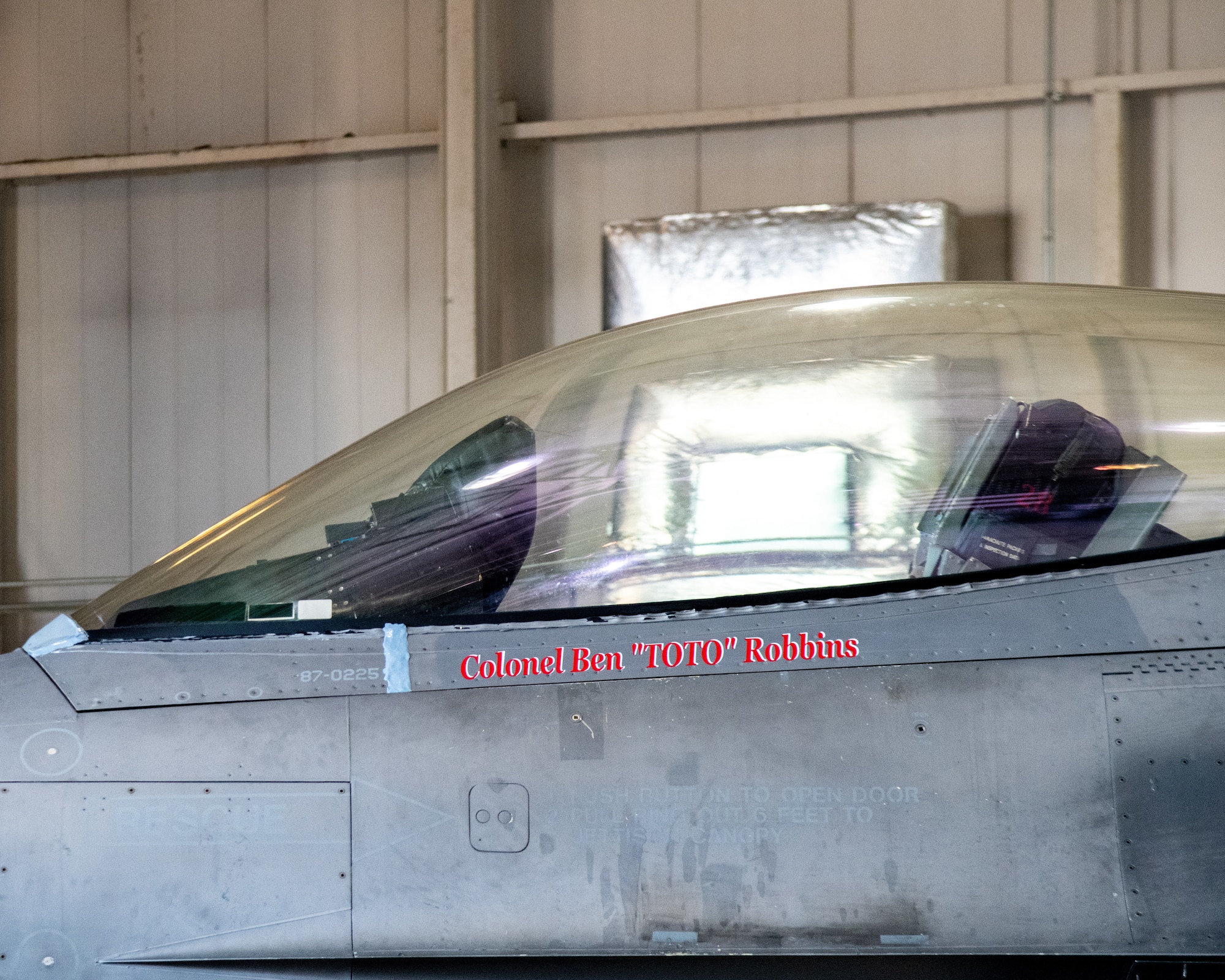 An F-16C sits on display. The pilots name painted on the aircraft reads "Colonel Ben 'Toto' Robbins"