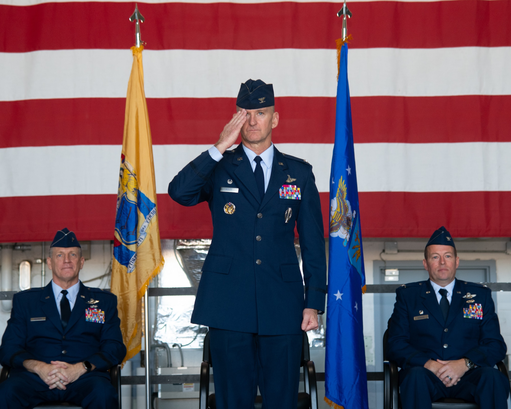 A man wearing Air Force service blues renders a salute.