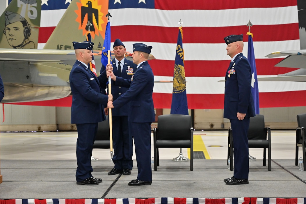 Commanders pass a flag to each other.