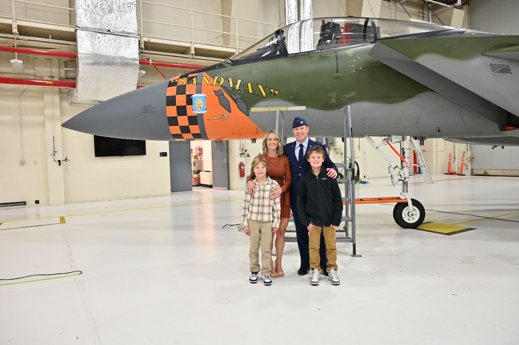 People pose for a picture in front of a F-15.