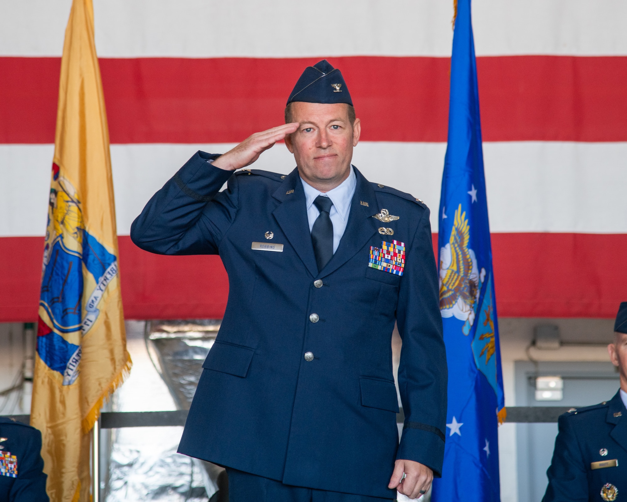 A man wearing Air Force dress blue renders a salute.