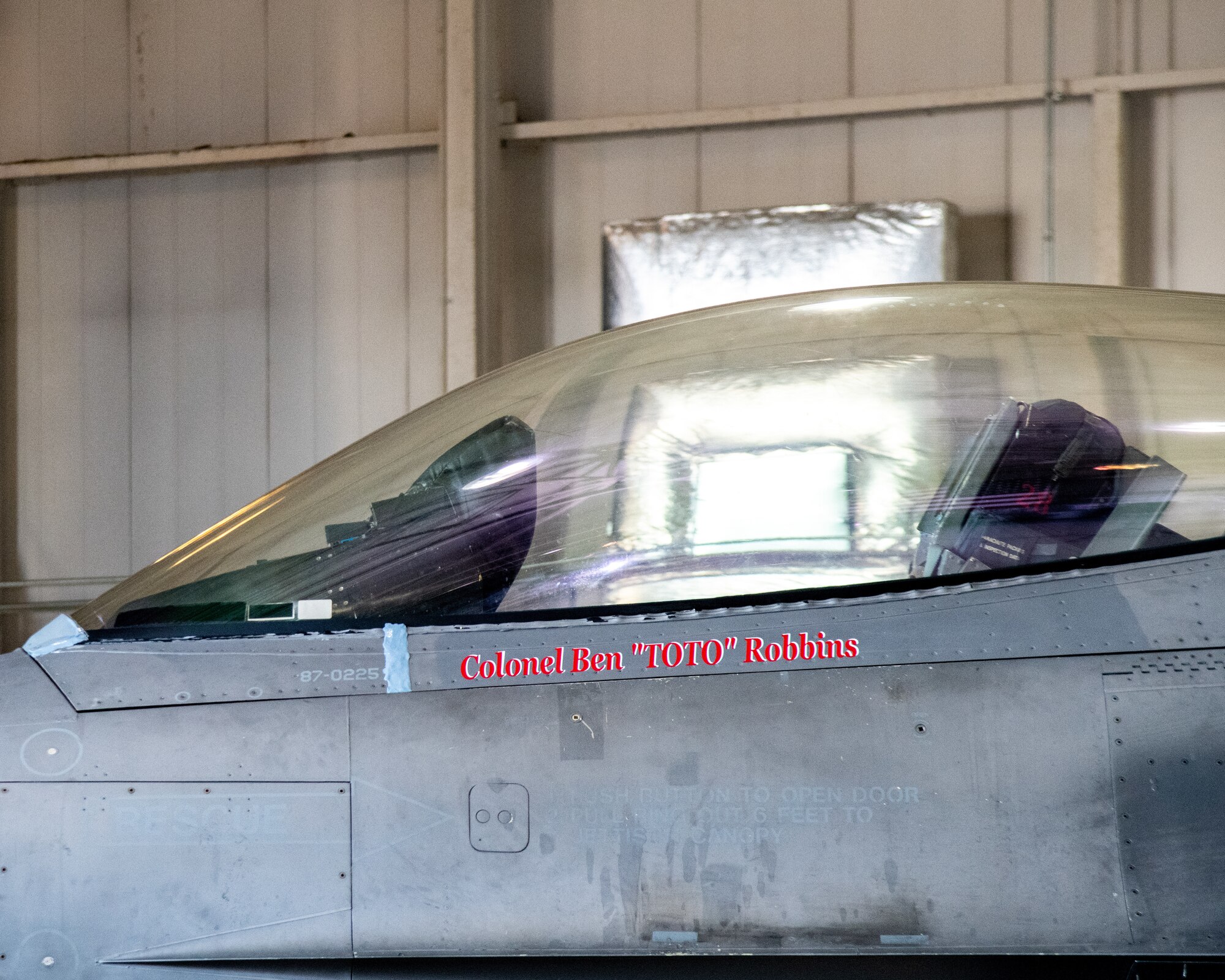 An F-16C sits on display. The pilots name painted on the aircraft reads "Colonel Ben 'Toto' Robbins"