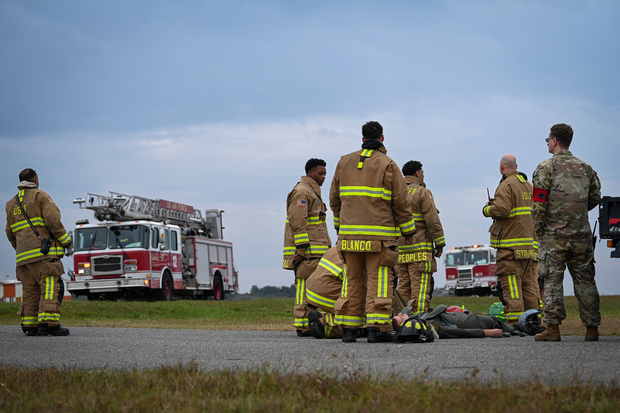 U.S. Air Force firefighters, assigned to the 8th Civil Engineer Squadron, wait for medical personnel to arrive at the scene during a mass accident response exercise.