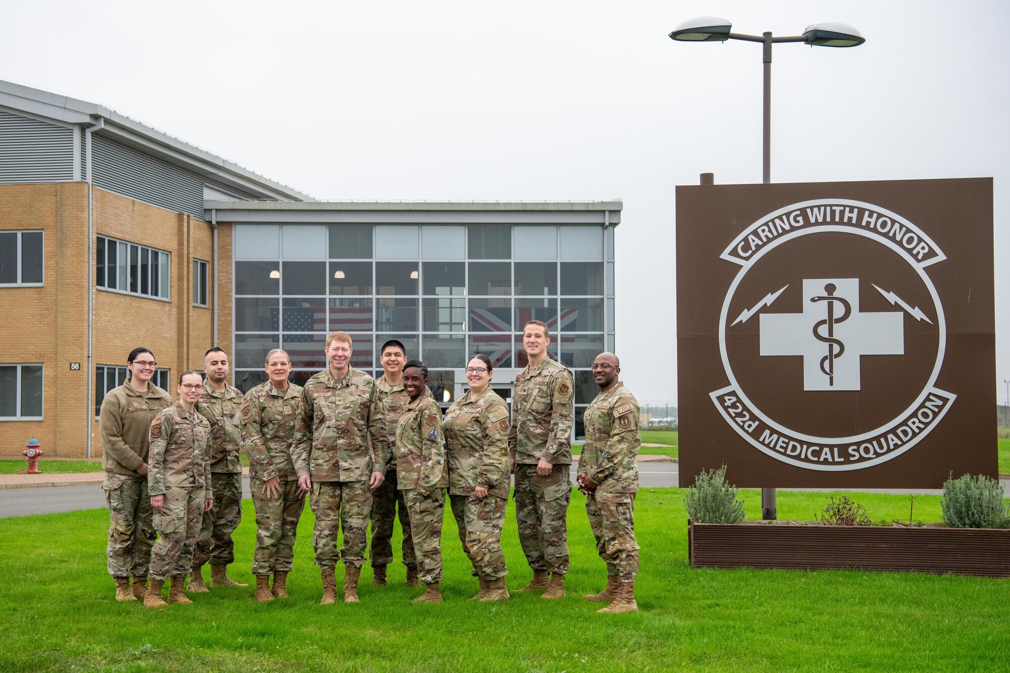 Airmen pose for a group photo outside of the 422nd Medical Squadron building