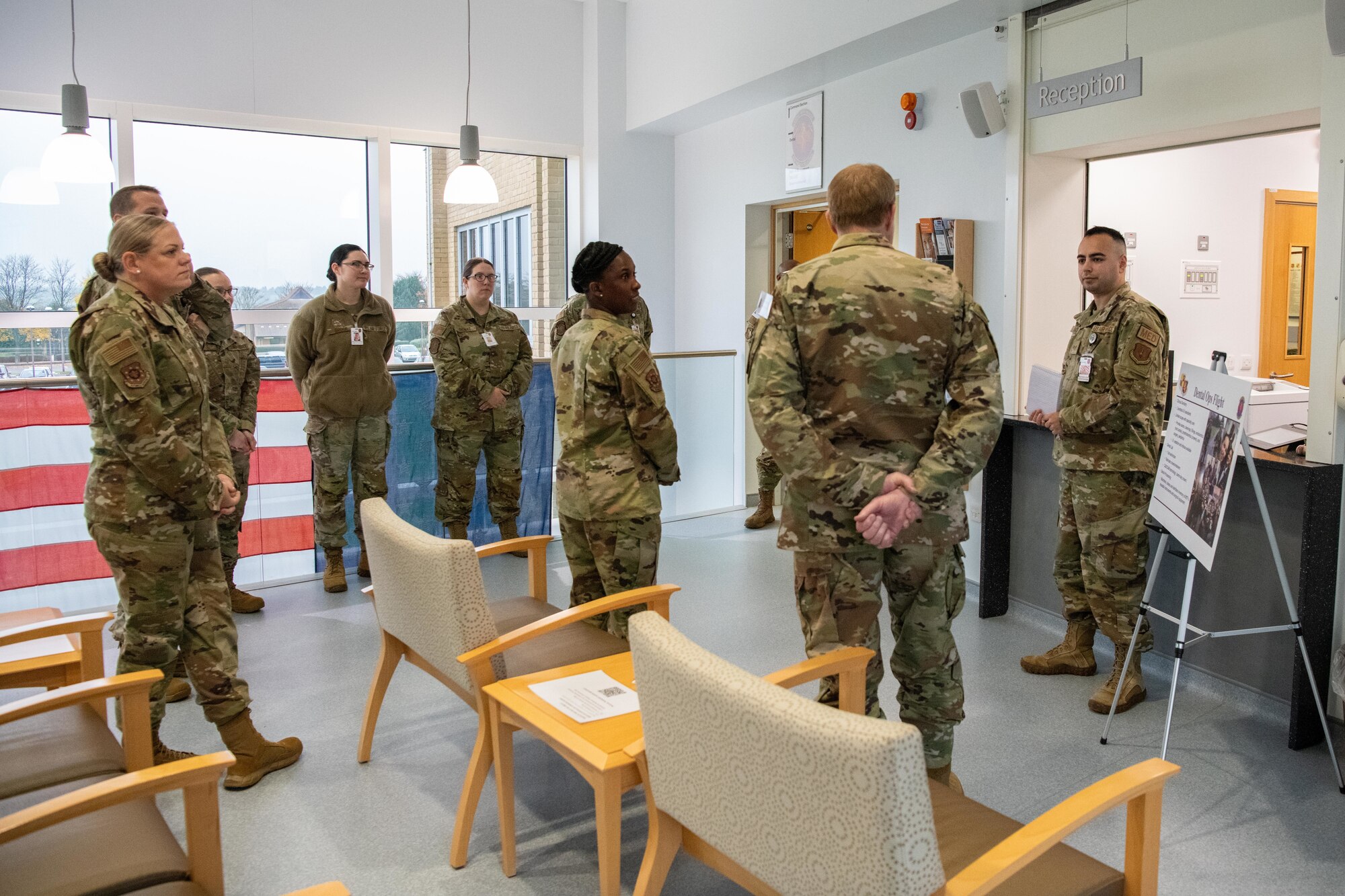 Airmen listen to a brief in a lobby