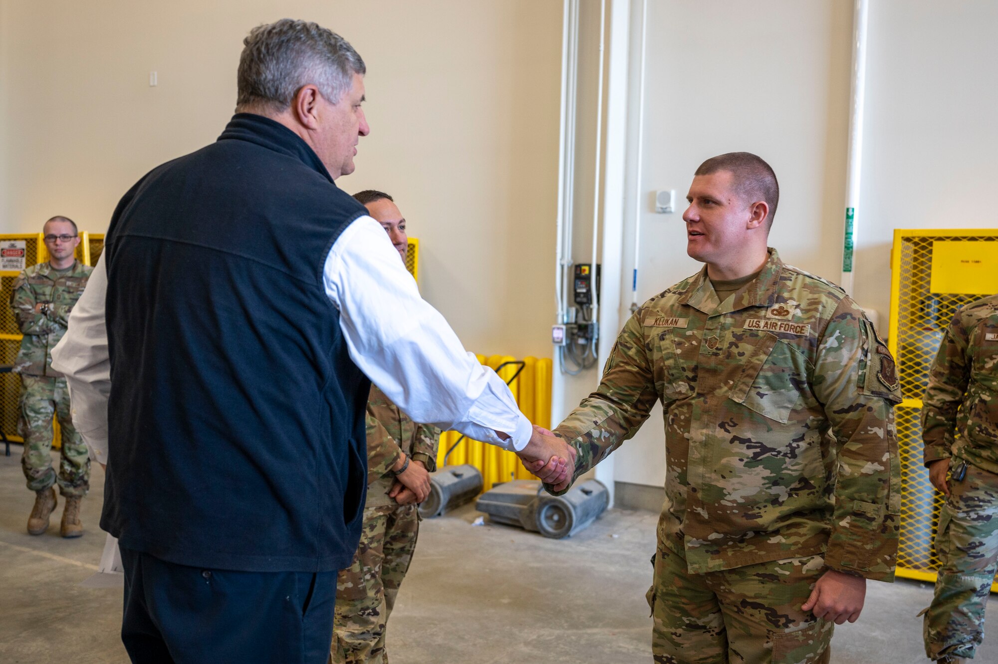 An Airman shakes a mans hand.