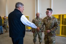 An Airman shakes a mans hand.