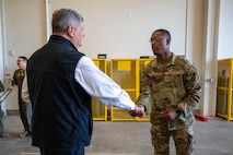An Airman shakes a mans hand.