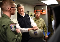 Two men listen to an Airman talk.
