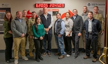 A group of people pose for a photo in front of a clock.
