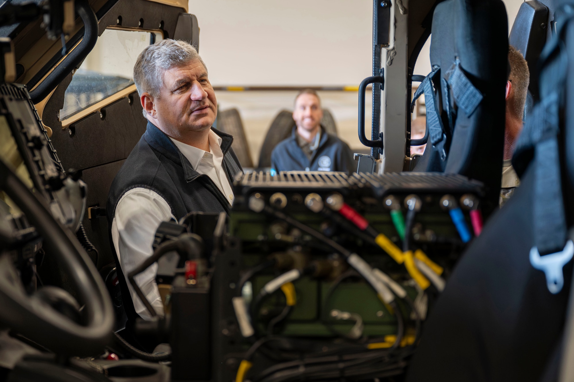 A man looks inside a military grade vehicle.