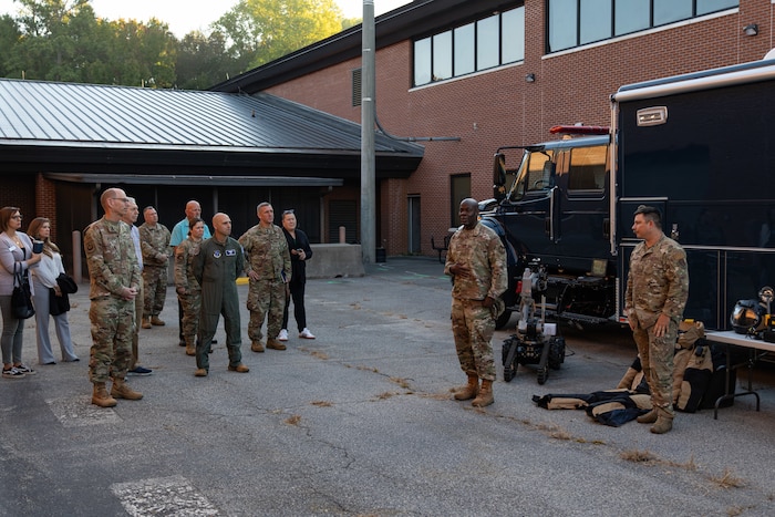Photo shows group of people standing around equipment on ground