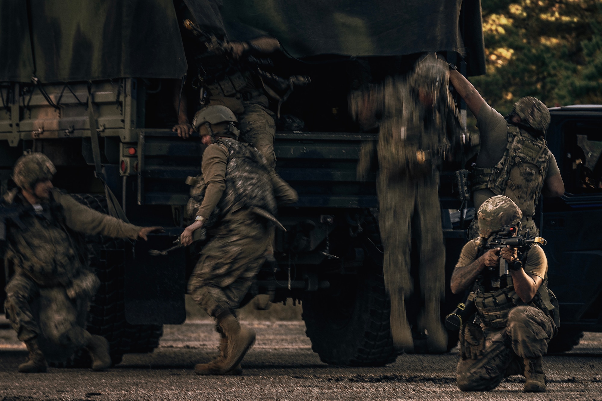 U.S. Air Force Airmen assigned to the 87th Civil Engineer Squadron exit a transport vehicle, after a simulated helicopter attack on their base camp, during Operation Honey Badger at Joint Base McGuire-Dix-Lakehurst, N.J., Oct. 24, 2024. Operation Honey Badger was an exercise to prepare participants for austere troop deployment and collaboration between separate career fields. (U.S. Air Force photo by Staff Sgt. Austin Knox)