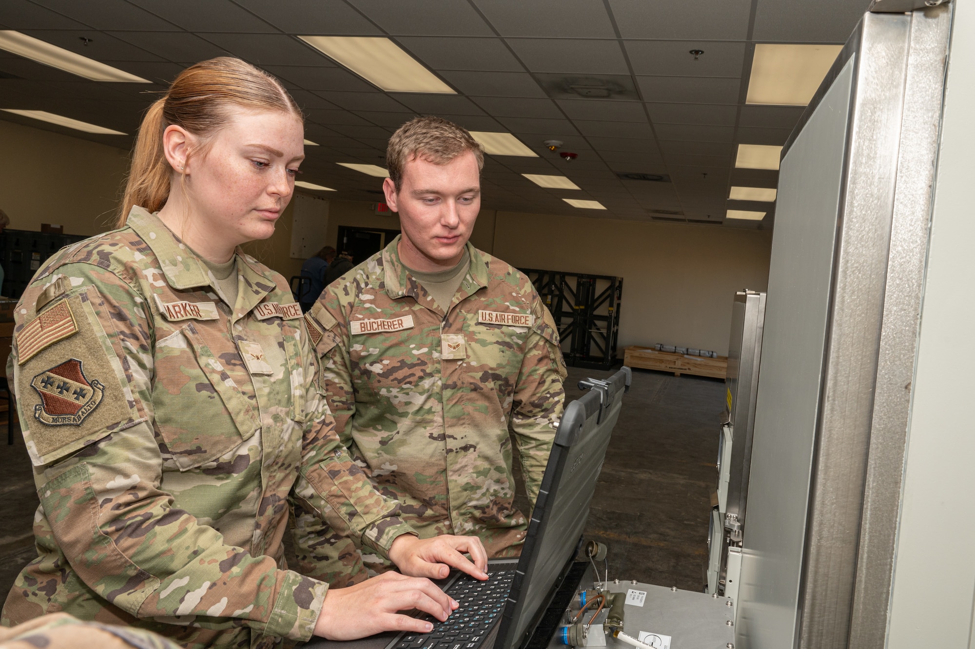 U.S. Air Force Airman Isabel Parker, 7th Bomb Wing command post domain command and control specialist, and Airman 1st Class Zachary Bucherer, 7th Communications Squadron network infrastructure technician, examine the Global Aircrew Strategic Network Terminal console system at Dyess Air Force Base, Oct. 31, 2024. The GASNT ensures secure communication for aircrew in the face of a nuclear attack or electromagnetic pulse. (U.S. Air Force photo by Senior Airman Alondra Cristobal Hernandez)