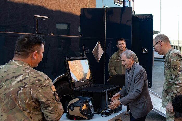 Photo shows people looking at equipment on table