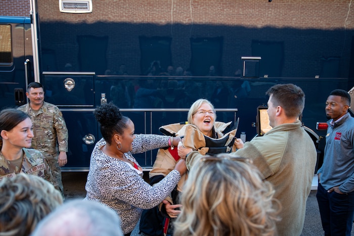Photo shows people helping woman put on bomb suit