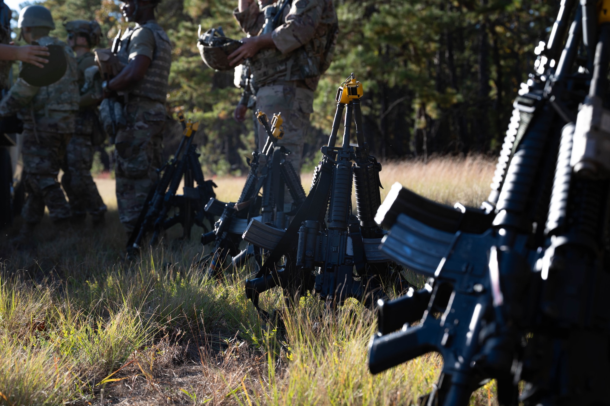 U.S. Air Force Airmen assigned to the 87th Civil Engineer Squadron, secure their weapons before setting up their base camp during Operation Honey Badger at Joint Base McGuire-Dix-Lakehurst, N.J., Oct. 20, 2024. Gear accountability is an integral part in ensuring personnel practice as they would perform during a real deployment, lowering the likelihood of equipment mishaps. (U.S. Air Force photo by Senior Airman Aidan Thompson)