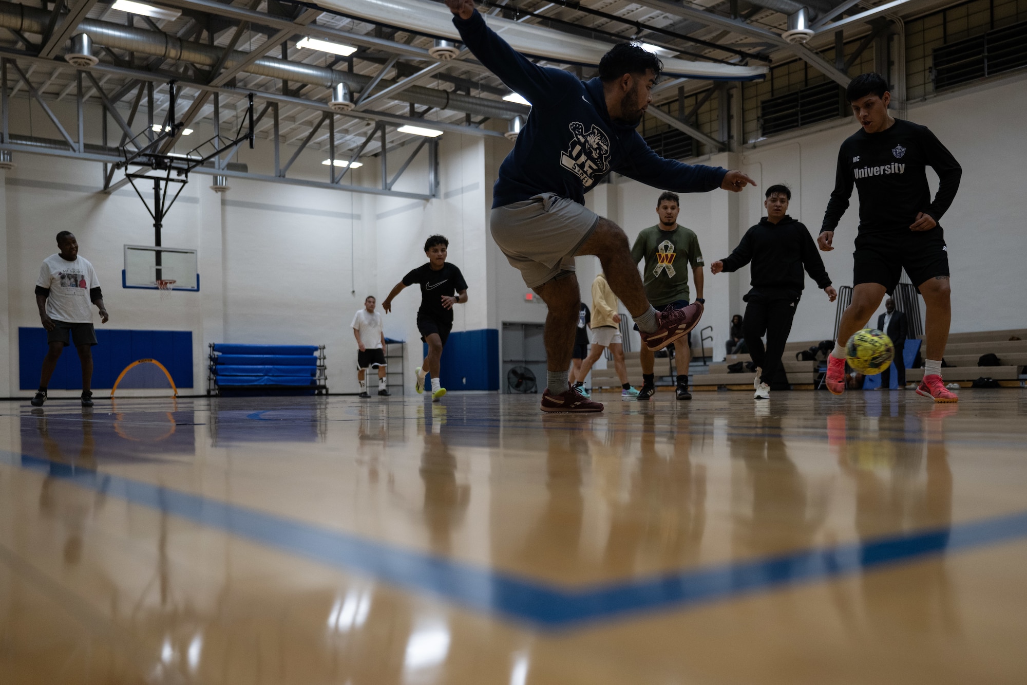 A player kicks a soccer ball during an indoor soccer game at Joint Base Andrews, Md., Oct. 17, 2024. These games bring together service and community members, promoting teamwork and trust among participants. (U.S. Air Force photo by Airman 1st Class Daniel Walderbach)