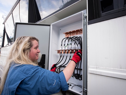 Engineer Beka Deason, a member of the Naval Information Warfare Center (NIWC) Atlantic Air Traffic Control (ATC) Special Programs team, inspects the coaxial cables of a new, medium mobile ATC tower the team is developing to be rapidly deployed to airfields during emergencies due to inclement weather, equipment failure or other disruptions.