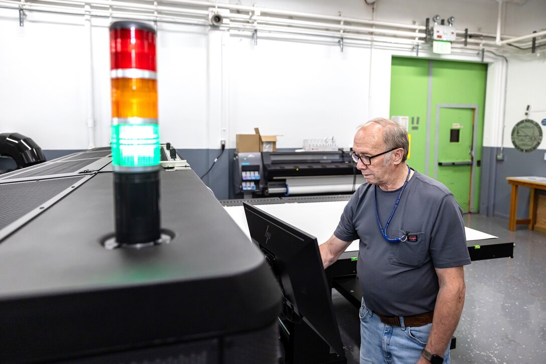 Sign Shop Fabricator James Kelley loads magnetic print media into a large format latex printer, Oct. 29, 2024, while working in the Shop 71 Sign Shop, at Puget Sound Naval Shipyard & Intermediate Maintenance Facility in Bremerton, Washington. (U.S. Navy photo by Jeb Fach)