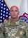 Photo of Command Sgt. Maj.posing for command photo in front of U.S. flag and United States Recruiting Command (USAREC) flag.