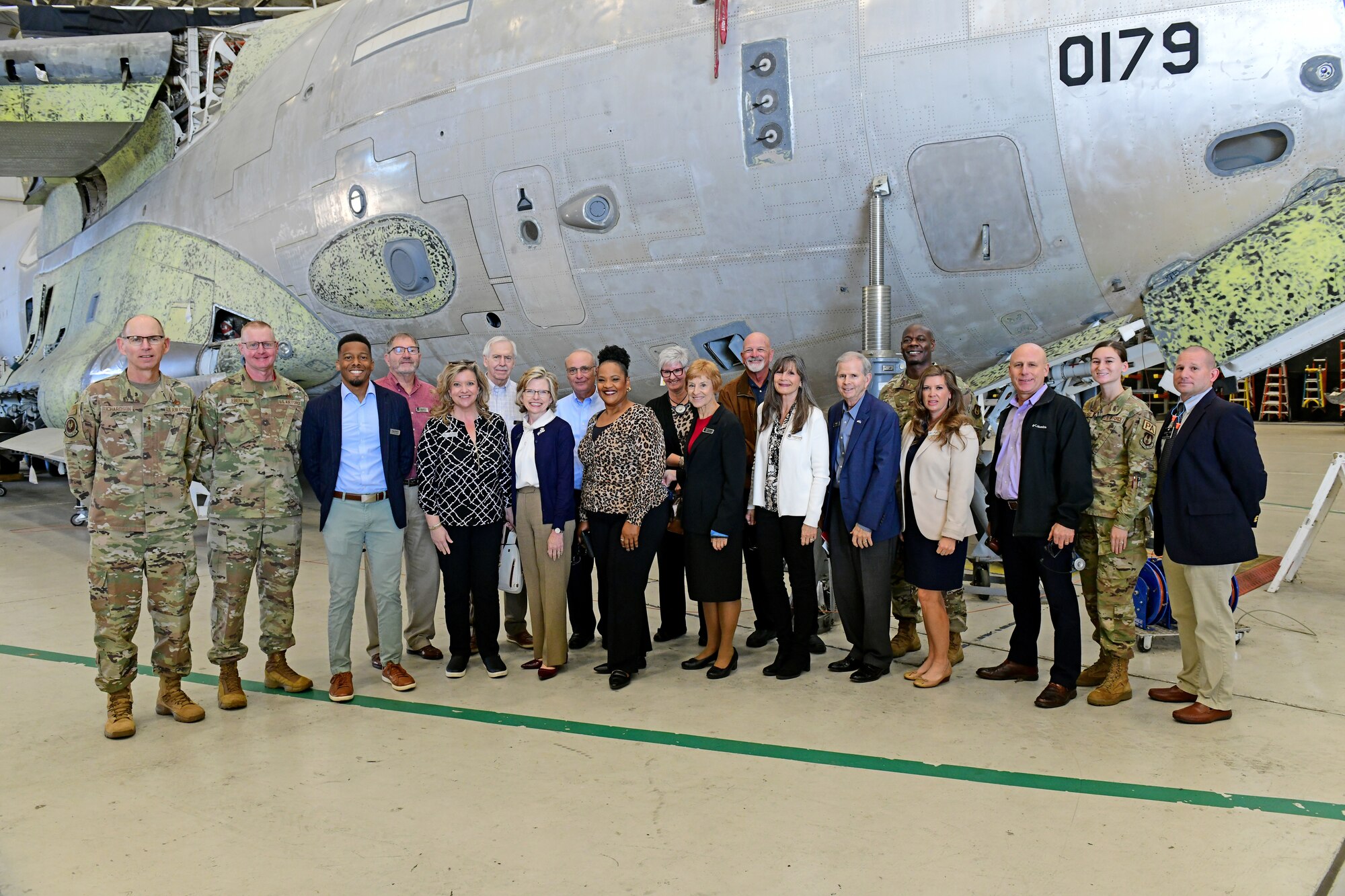 Photo shows group of people in front of aircraft