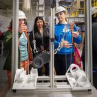Porsha Molina, continuous training and development supervisor, Code 740, Riggers, helps visiting educators, Megan Bartleson, Olympic High School in Bremerton, and Valerie Johnson, U.S Naval Undersea Museum Keyport, as they try their hand at working a mock up “chainfall” Oct. 21, 2024, during the annual Puget Sound Naval Shipyard & Intermediate Maintenance Facility Educator Day, in Bremerton, Washington. Educators from various academic institutions took part in the day-long learning event. (U.S. Navy photo by Wendy Hallmark)