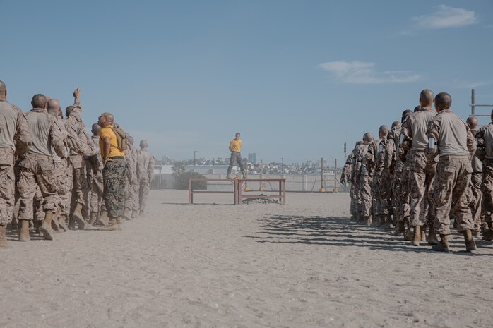 U.S. Marine Corps Staff Sgt. Robert Stanton, a chief drill instructor with Fox Company, 2nd Recruit Training Battalion, guides recruits through dynamic warm-ups prior to the confidence course training event at Marine Corps Recruit Depot San Diego, California, Oct. 24, 2024. The confidence course challenges recruits physically and mentally through obstacles that require confidence in their strength, balance, and determination. (U.S. Marine Corps photo by Cpl. Sarah M. Grawcock)