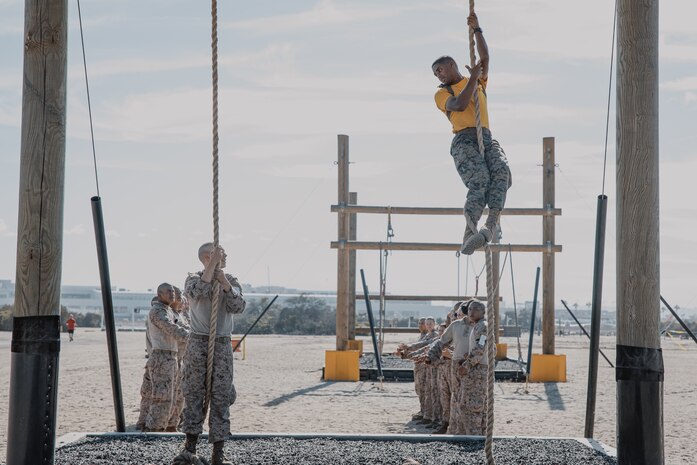 U.S. Marine Corps Sgt. Justin Miranda, a drill instructor with Fox Company, 2nd Recruit Training Battalion, instructs a recruit on how to properly climb a rope during a confidence course training event at Marine Corps Recruit Depot San Diego, California, Oct. 24, 2024. The confidence course challenges recruits physically and mentally through obstacles that require confidence in their strength, balance, and determination. (U.S. Marine Corps photo by Cpl. Sarah M. Grawcock)