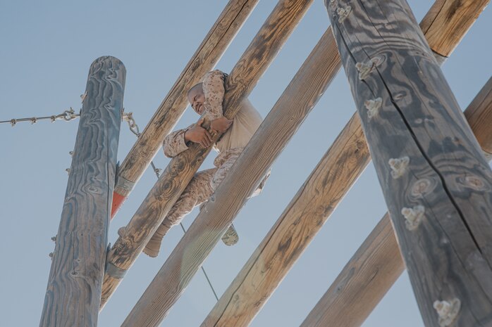 A U.S. Marine Corps recruit with Fox Company, 2nd Recruit Training Battalion, climbs up an obstacle during a confidence course training event at Marine Corps Recruit Depot San Diego, California, Oct. 24, 2024. The confidence course challenges recruits physically and mentally through obstacles that require confidence in their strength, balance, and determination. (U.S. Marine Corps photo by Cpl. Sarah M. Grawcock)