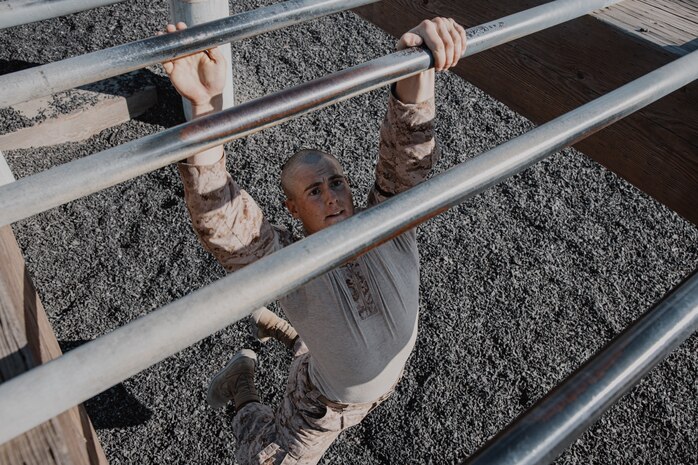 A U.S. Marine Corps recruit with Fox Company, 2nd Recruit Training Battalion, navigates through an obstacle during a confidence course training event at Marine Corps Recruit Depot San Diego, California, Oct. 24, 2024. The confidence course challenges recruits physically and mentally through obstacles that require confidence in their strength, balance, and determination. (U.S. Marine Corps photo by Cpl. Sarah M. Grawcock)