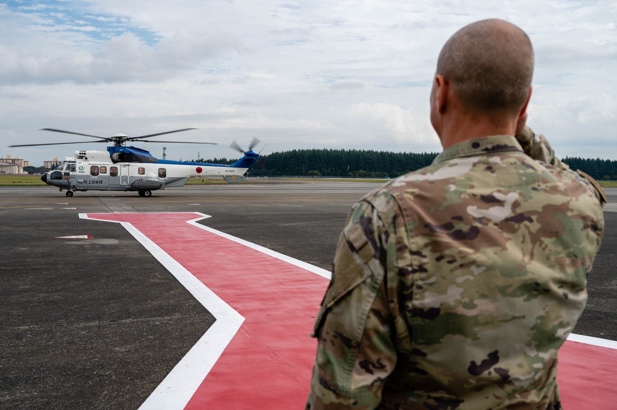 U.S. Air Force Col. Brett Cochran, 374th Airlift Wing deputy commander, salutes Honorable Gen Nakatani, Japan's Minister of Defense, as he lands in a helicopter at Yokota Air Base, Japan.