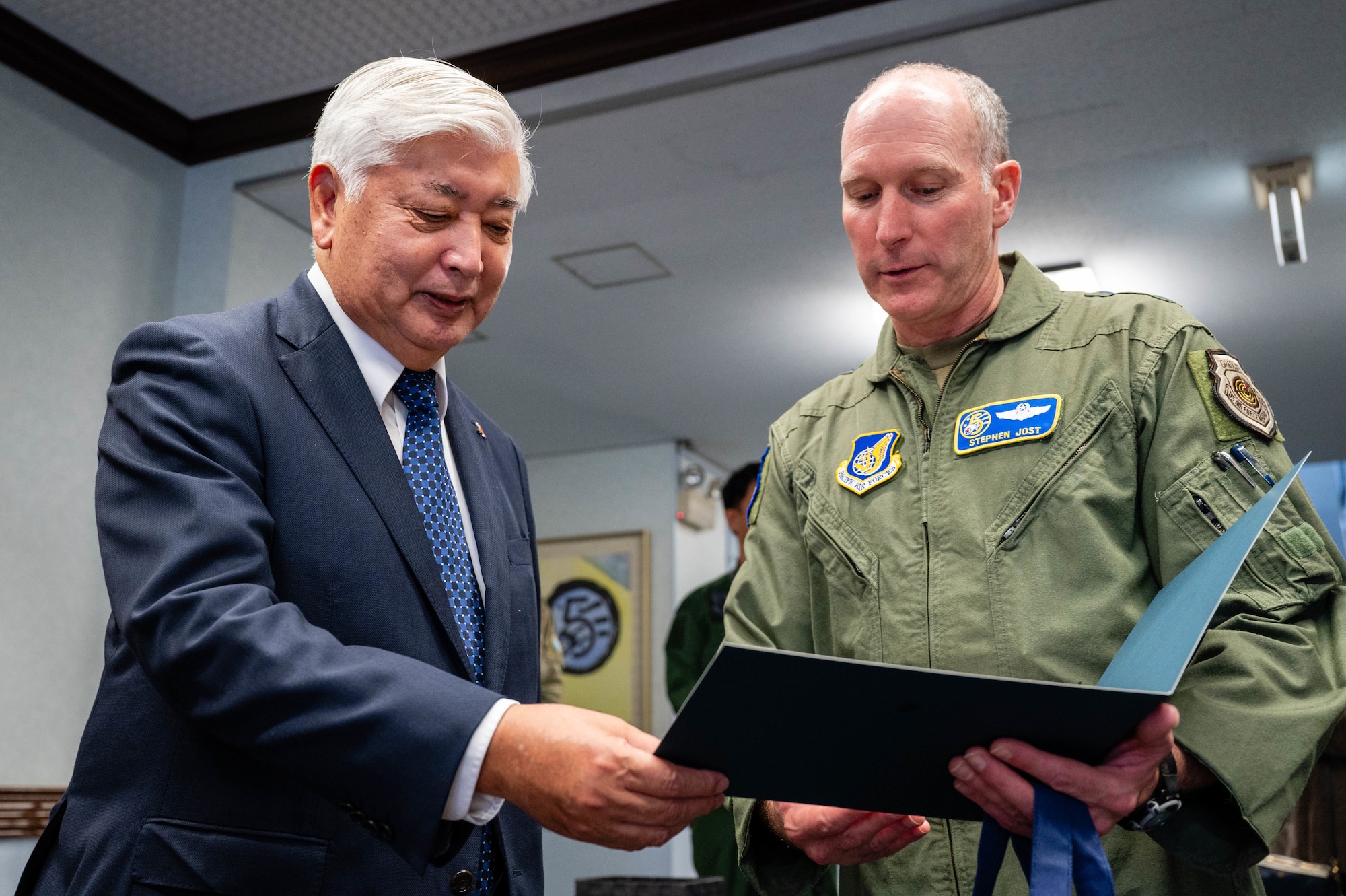 U.S. Air Force Lt. Gen. Stephen Jost, U.S. Forces Japan and Fifth Air Force commander, presents Honorable Gen Nakatani, Japan's Minister of Defense, with a photo of the two of them posing in front of the distinguished visitor garden marquee at Yokota Air Base, Japan.