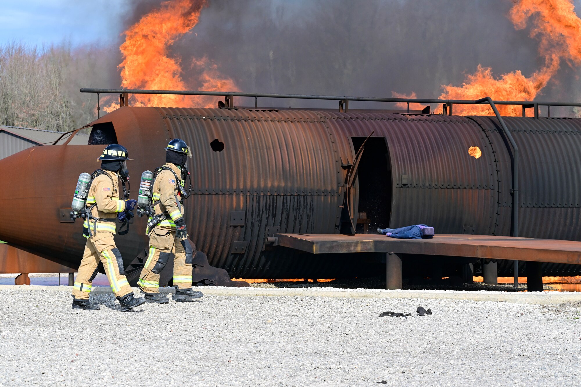 Firefighters assigned to the 910th Civil Engineer Squadron spot a staged casualty on the wing of a burning aircraft simulator, Nov. 4, 2024, during Combat Readiness Exercise Buckeye II at Youngstown Air Reserve Station, Ohio.