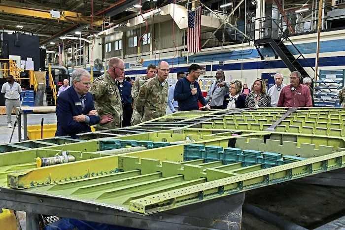 Photo shows group of people looking at the inside of an aircraft wing.