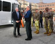 Secretary of the Air Force talks with a civilian outside, before building tour.