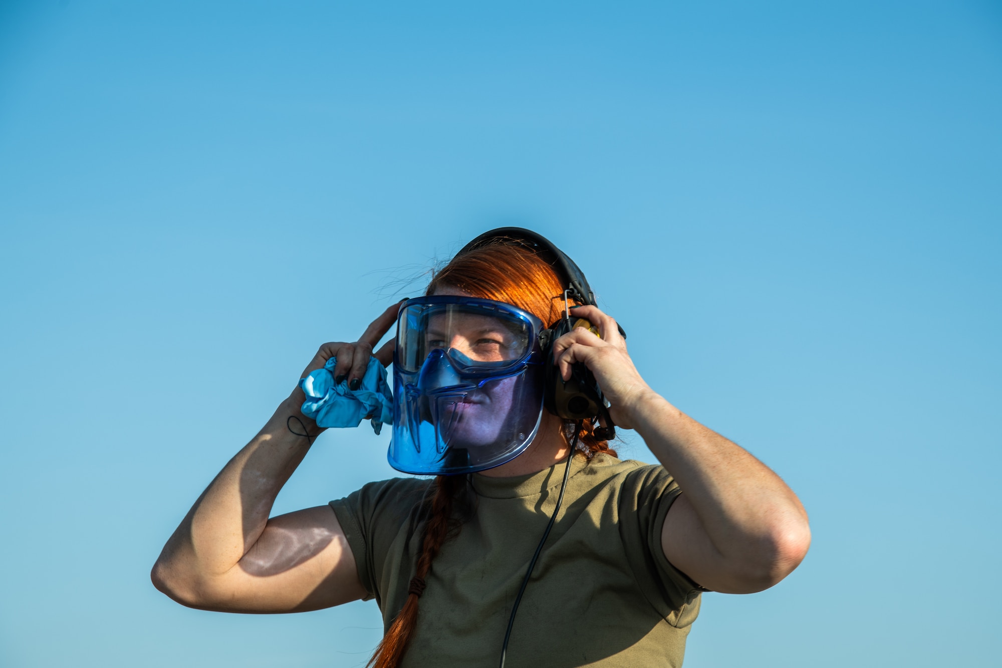 A female aircraft maintainer wears personal protective equipment.