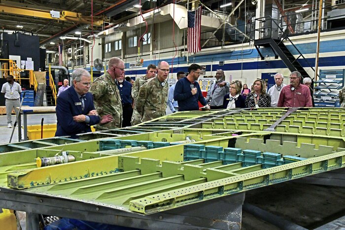Photo shows group of people looking at the inside of an aircraft wing.