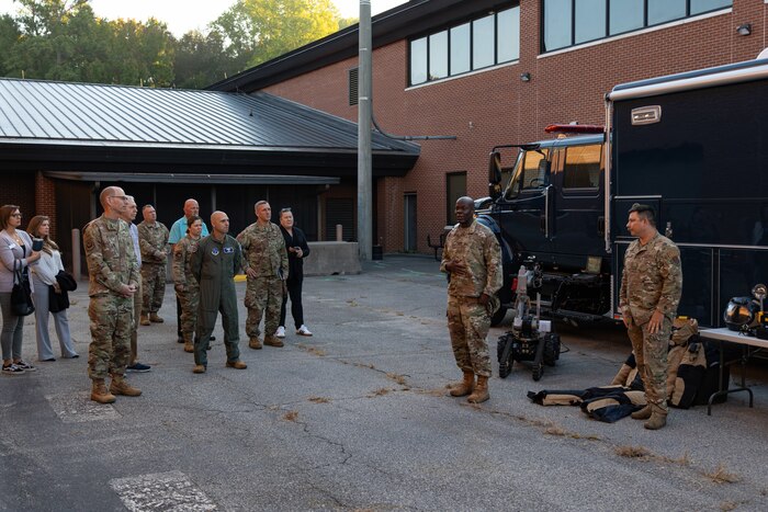 Photo shows group of people standing around equipment on ground