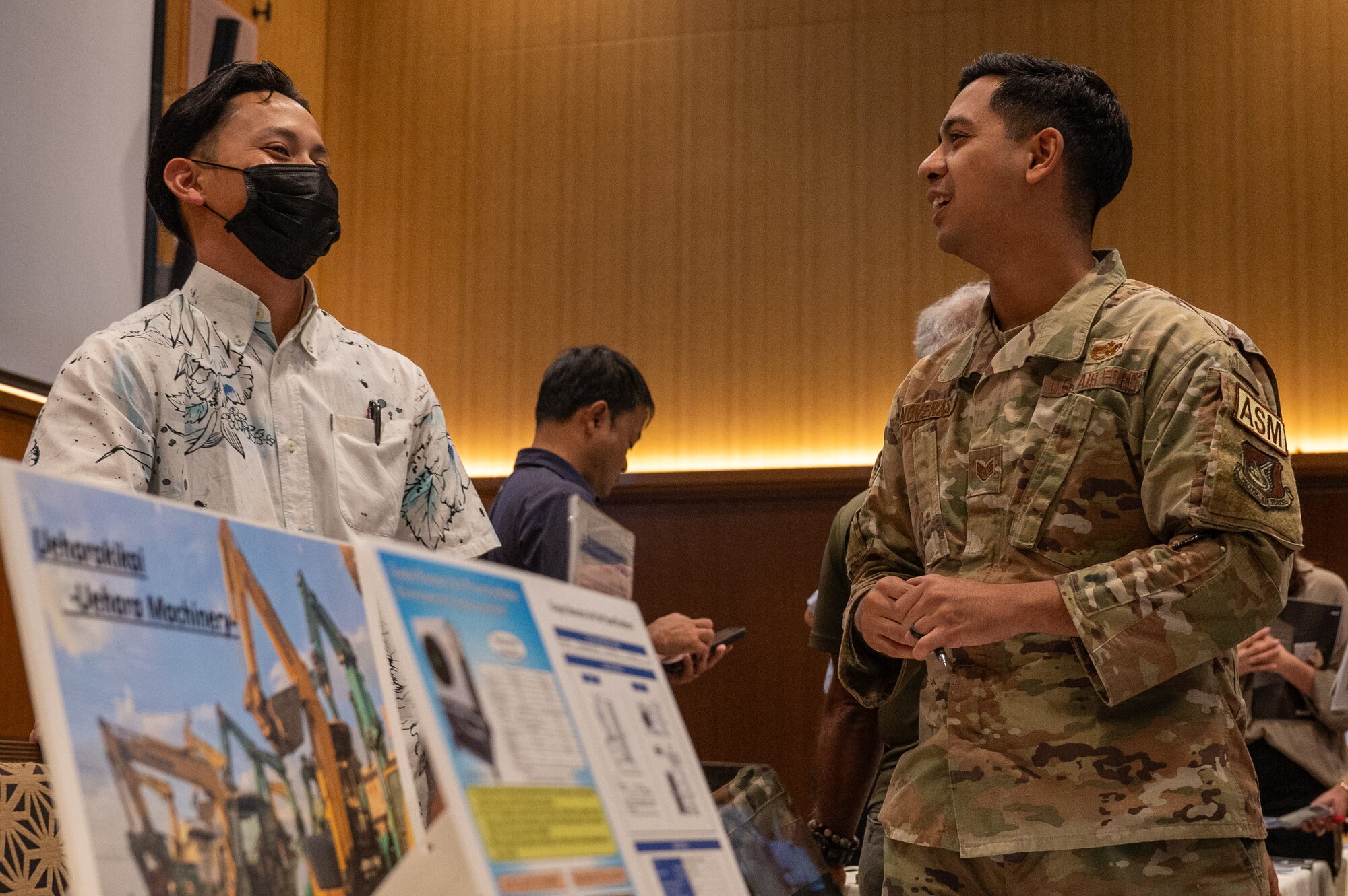 military member and civilian contractor talk to each other.