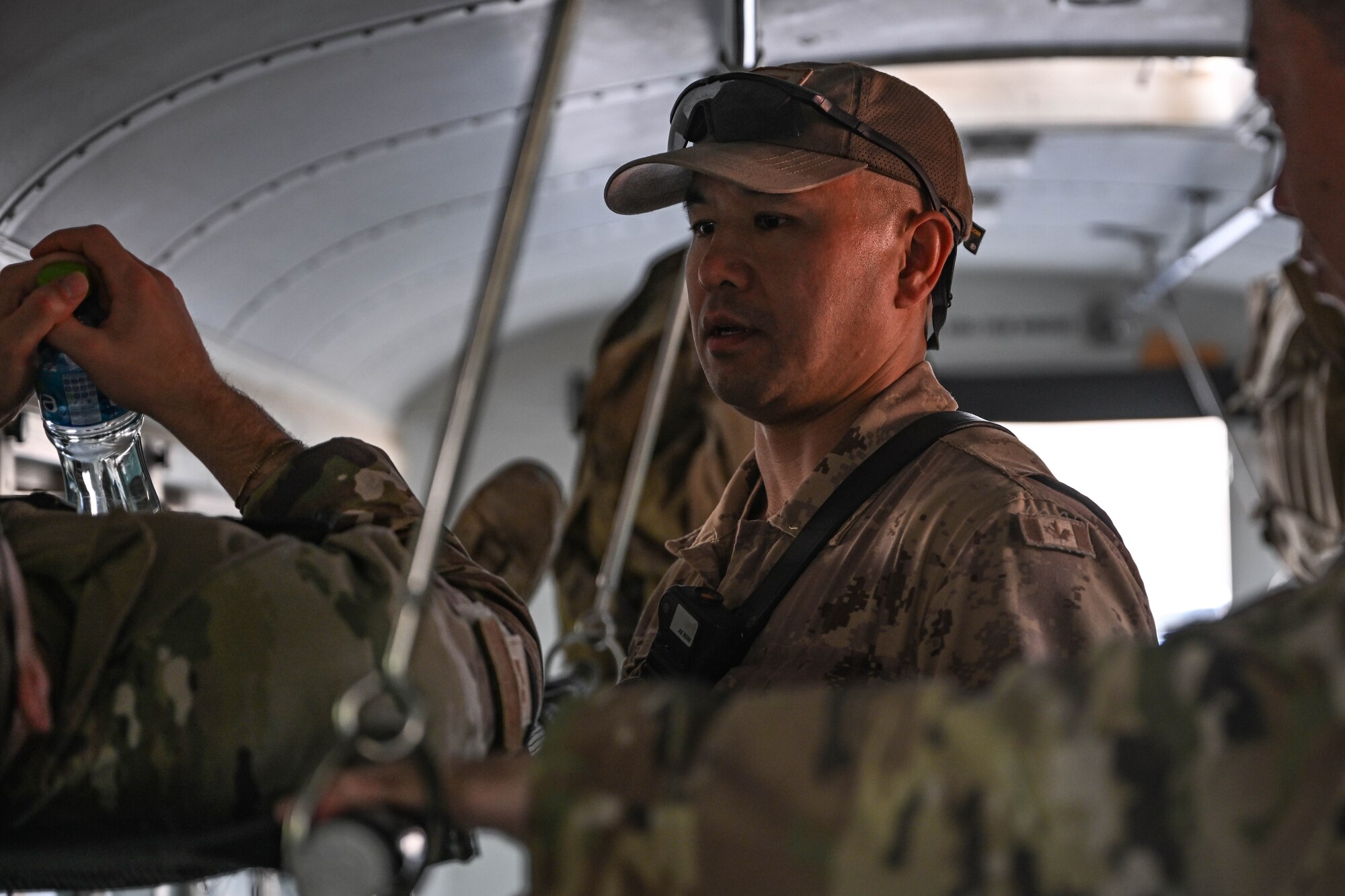 A man in uniform looks at a litter patient.